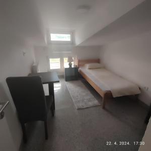a small bedroom with a bed and a desk at Apartman Numero Uno in Vogošća