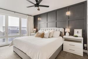 a bedroom with a large white bed with a black wall at 4BR Upscale Townhome Roof Top w Skyline Views in Denver