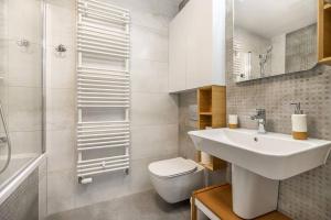 ein weißes Bad mit einem Waschbecken und einem WC in der Unterkunft Șoseaua Pipera the Best Host Apartments in Herăstrău