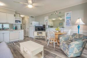a living room with a couch a table and a kitchen at Sea Cabin- Ocean Front Condo in Myrtle Beach