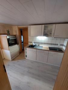 a large kitchen with white cabinets and a sink at Ferienwohnung-Barth in Schwarzenberg/Erzgebirge