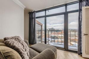 a living room with a couch and a large window at Larimer Luxury Top Notch Amenities Walk to All in Denver