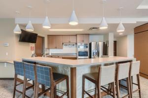 a kitchen with a large island with bar chairs at Larimer Luxury Top Notch Amenities Walk to All in Denver