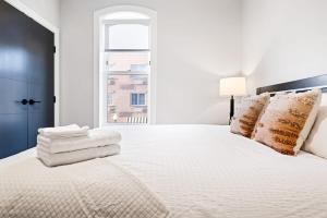 1 dormitorio blanco con 1 cama blanca grande con almohadas en Avenue Hotel Downtown Golden Clear Creek Suite, en Golden