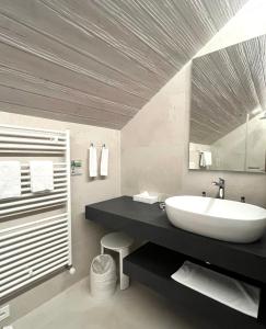 ein Badezimmer mit einem weißen Waschbecken und einem Spiegel in der Unterkunft Romantik Hotel Castello Seeschloss in Ascona