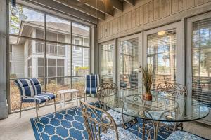 balcón con mesa de cristal y sillas en Teal lake 1311, en North Myrtle Beach