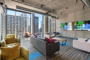 シカゴにあるLinea Luxury Living with Indoor Pool and Rooftop Views in The Loopのソファと大きな窓のあるリビングルーム