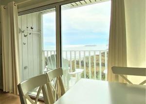 a room with a table and chairs and a balcony at The Sea Shed- Ocean Front Condo in Myrtle Beach