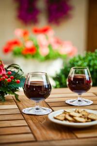 two glasses of wine and crackers on a wooden table at Logis Hôtel Belle Epoque in Beaune +18 photos