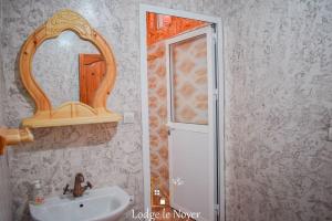 een badkamer met een wastafel en een spiegel bij Lodge Le Noyer in Aït Imi