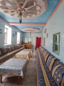 a room with rows of beds with a ceiling at Lodge Le Noyer in Aït Imi