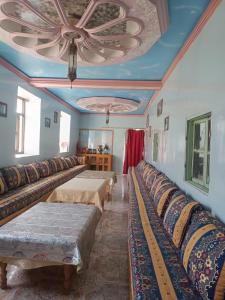 een kamer met rijen bedden met een plafond bij Lodge Le Noyer in Aït Imi