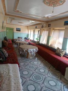 una habitación con sofás y mesas en un edificio en Lodge Le Noyer en Aït Imi