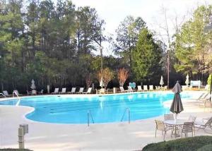 a large swimming pool with chairs and a table at Teal Lake 212 in North Myrtle Beach