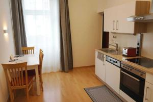eine kleine Küche mit einem Tisch und einer Arbeitsplatte in der Unterkunft Serenity Apartment 45m2 Free Parking in Leoben