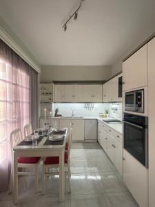 a kitchen with a table and chairs and a kitchen with white cabinets at Summer Diamond in Kremasti