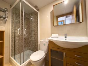 y baño con aseo, lavabo y ducha. en Acogedor apartamento cerca de la playa wifi y parking, en Mont-roig