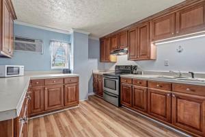 a kitchen with wooden cabinets and wooden floors at Charming Condo one block from the beach - WR 301 in Myrtle Beach