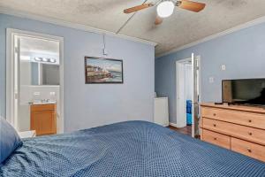 a bedroom with a bed and a flat screen tv at Charming Condo one block from the beach - WR 301 in Myrtle Beach