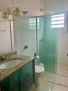 a bathroom with a toilet and a sink and a shower at Casa Janela Verde in São José da Barra