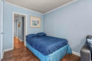 a bedroom with a bed in a room with blue walls at Charming Condo one block from the beach - WR 301 in Myrtle Beach