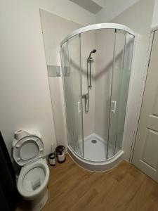 a bathroom with a shower and a toilet at Crete Room in Oldham