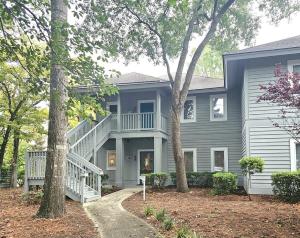 a blue house with a white staircase and trees at Teal Lake 1413 in North Myrtle Beach