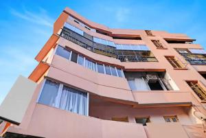 un alto edificio rosa con finestre di Hotel Laxmi Guest House Jadavpur - Excellent Service a Calcutta