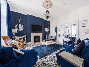 a living room with blue furniture and a fireplace at Lazy Waves Boutique B&B in Newquay