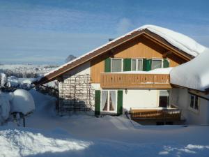 una casa con nieve en el techo en Ferienwohnung Hörnle en Bad Kohlgrub