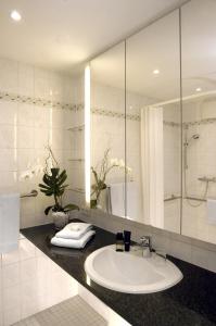 a bathroom with a sink and a mirror at Residenz am Dom Boardinghouse Apartments in Cologne