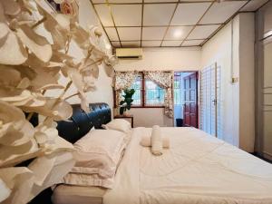 ein Schlafzimmer mit einem großen Bett mit weißer Bettwäsche in der Unterkunft Botanical Retro-Cottage by StayCo - Riverview Pool in George Town
