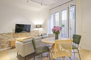 - un salon avec un canapé et une table avec des chaises dans l'établissement Ola Living Diagonal Apartments, à Barcelone