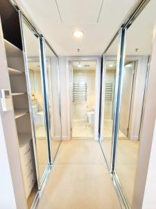 um closet com portas de vidro e um WC em Holiday Style 2 BRStudy Apartment in Olympic Park em Sydney