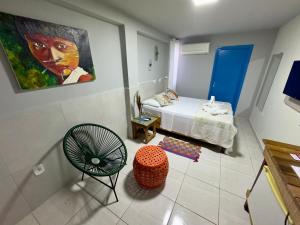 Habitación con cama y pintura en la pared en Cambará Suítes, en Bonito