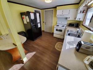 a small kitchen with a black refrigerator and a table at Spacious ATV Retreat House in Rock