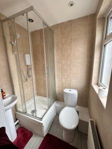 uma casa de banho com um chuveiro, um WC e um lavatório. em Quirky Oasis Queens em Liverpool