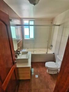 La salle de bains est pourvue de toilettes, d'un lavabo et d'une baignoire. dans l'établissement Beautiful apartment in Calacoto, à La Paz