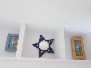 a black star on a white wall with pictures at Casa 7 Parc Sant Ramon descanso y armonía in Platja d'Aro