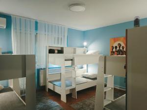 a bedroom with a white bunk bed and blue walls at Hostel Central Skopje in Skopje