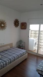 1 dormitorio con 1 cama y puerta corredera de cristal en Pis Embaixador 1a línea de mar, en Platja d'Aro
