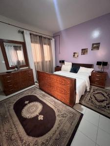 - une chambre avec un grand lit et un grand tapis dans l'établissement COMPLEXE BLUE PHOENIX, à Dakar