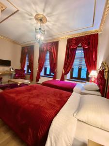um quarto com uma grande cama vermelha com cortinas vermelhas em Hotel Katerina Sarayı 1877 em Kars