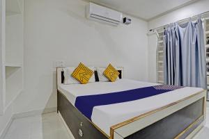 a bedroom with a bed with yellow and blue pillows at OYO Amer Inn in Kharka