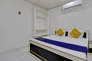 a bedroom with a bed with blue and yellow pillows at OYO Amer Inn in Kharka