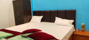a bedroom with a bed with red and white pillows at HOTEL AYODHYA PAYING GUEST in Ayodhya