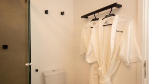 a bathroom with white clothes on a rack next to a toilet at Flat Jardim Paulista II - SP - Próximo da AV Paulista e ao lado do Shopping Pamplona in Sao Paulo