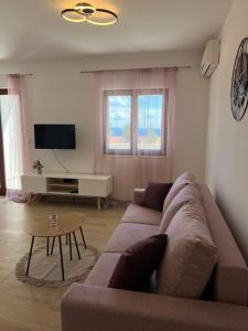 ein Wohnzimmer mit einem Sofa und einem Tisch in der Unterkunft Apartmani Vranković in Sveta Nedelja