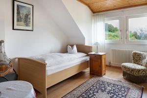 a bedroom with a bed and a chair and a window at Zum Alt Engelwirt in Horben