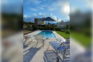 - une terrasse avec des chaises et un parasol à côté de la piscine dans l'établissement Complejo en El Encon: ¡Disfruta de la Naturaleza y la Comodidad a Solo Minutos de Salta, à Salta